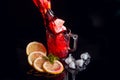 Hibiscus cold tea pouring into glass with ice, lemon and mint isolated on black background Royalty Free Stock Photo