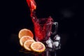 Hibiscus cold tea pouring into glass with ice, lemon and mint isolated on black background Royalty Free Stock Photo