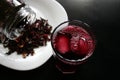 Hibiscus tea. Cold drink with portion of hibiscus flowers in the jar and on the white plate.