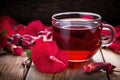 Hibiscus tea in a glass cup on a wooden table among the rose petals and dry tea. Vitamin tea for cold and flu Royalty Free Stock Photo