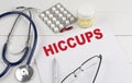 HICCUPS word on paper with stethoscope and pills