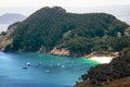 Hidden beach surrounded by wooded hills in the Cies Islands, Spain. Turquoise water with small boats