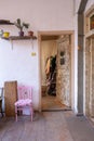 Hidden second-hand clothing store with pink chairs, plants, shelves, a wardrobe, and white walls. Royalty Free Stock Photo