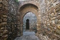 Hidden stone passageway in Malaga fortress with archs and gate Royalty Free Stock Photo