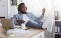 Cheerful employee playing virtual guitar while listening music at workplace Royalty Free Stock Photo