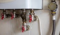 Hidden water taps for connecting a gas boiler on a tiled wall. Plumbing connections for a domestic double-circuit gas Royalty Free Stock Photo