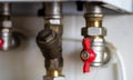 Hidden water taps for connecting a gas boiler on a tiled wall. Plumbing connections for a domestic double-circuit gas Royalty Free Stock Photo