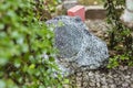 A hidden weatherproof rock speaker blending into an outdoor landscaped garden