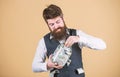Hiding money for future use. Bearded man investing money from glass jar for future profits. Businessman focusing on