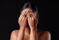 Hiding, shame and portrait of a woman covering face on a black background in a studio. Shy, fear and girl with