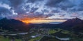 Hiding sun behind mountain chain hahnenkamm with view to village pflach