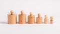 Hierarchy concept. Row of Montessori knobbed cylinders from bigger to smaller. Kids toy for development of dimension