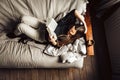 Hig angle view of a 30 yo woman in her sofa, reading a book with a coffee