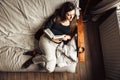 Hig angle view of a 30 yo woman in her sofa, reading a book with a coffee