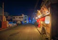 Higashikakogawa, Japan - May 5, 2023: Signs over brightly lit Japanese restaurant on quiet street at night