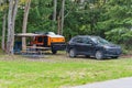 Small teardrop travel trailer parked at a state campground site