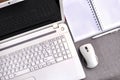 High above view of office workplace with laptop close up computer keyboard and mouse with notebook, pen on grey desk. Royalty Free Stock Photo