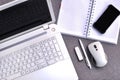 High above view of office workplace with mobile phone and laptop close up computer keyboard and mouse with notebook, pen and usb