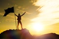 High achievement, silhouettes of the girl, flag of victory on the top of the mountain, hands up.