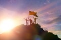 High achiever, silhouettes of three people holding on top of a mountain to raise their hands up. Royalty Free Stock Photo