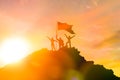 High achiever, silhouettes of three people holding on top of a mountain to raise their hands up. Royalty Free Stock Photo