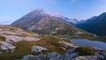 High altitude alpine lake in idyllic land with majestic rocky mountain peaks. Long exposure at dusk. Wide angle view on the Alps. Royalty Free Stock Photo