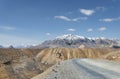 High altitude road with snow capped mountain background Royalty Free Stock Photo