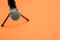 High angl shot of a microphone on a small stand, on an orange surface Royalty Free Stock Photo