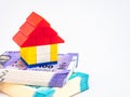 High angle close up shot of a lego house toy on stack of money in home loan concept