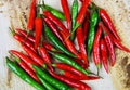 High angle close up view on isolated pile raw red green chillies on natural brown wood plate Royalty Free Stock Photo