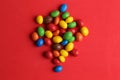 High angle closeup shot of colorful candy balls isolated on a red background Royalty Free Stock Photo