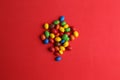 High angle closeup shot of colorful candy balls isolated on a red background Royalty Free Stock Photo
