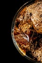 High angle closeup shot of a glass of alcoholic drink with ice cubes on a black background Royalty Free Stock Photo