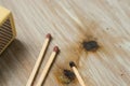 High angle closeup shot of matches on a burnt wood