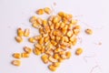 High angle closeup shot of a pile of peeled yellow corns on a white background