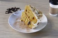 High angle closeup shot of a slice of a carrot cake on a wooden table with a drink on the side Royalty Free Stock Photo