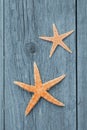 High angle closeup shot of two starfishes on a wooden surface