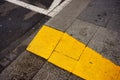 High angle closeup shot of a yellow line on the sidewalk Royalty Free Stock Photo