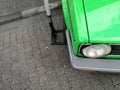 High angle closeup view of the headlights of an old vintage green car Royalty Free Stock Photo
