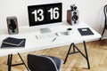 High angle of a desk with a computer, notebooks, speakers and keyboard next to a chair in a home office interior. Real photo Royalty Free Stock Photo