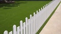 High angle and diagonal view of white artificial wooden fence on green artificial turf in front yard of home,  exterior Royalty Free Stock Photo