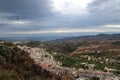 High-angle of Frigiliana houses trees mountains and cloudy sky background