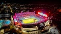 High angle of the glowing TIAA Bank Field with the lit Jacksonville cityscape at night in Florida