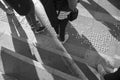 High angle greyscale of the feet of people standing on the ground under the sunlight in Sydney