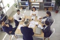 Team of young workers listening to senior manager sitting around office table in corporate meeting Royalty Free Stock Photo