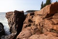 High angle horizontal view of the cliffs towering over Thunder Hole seen during an early sunny morning