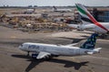 High-angle of Jetblue plane taxis past a giant Emirates plane at JFK Airport in New York