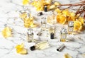 Collection of Luxury Perfume Bottles and Yellow Flowers on Marble Surface Royalty Free Stock Photo