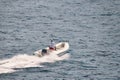 High-angle photo of an man driving a white rigid-hull inflatable boat in the water Royalty Free Stock Photo