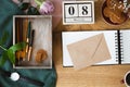 High angle photo of wooden table with envelope placed on notebook, box with brushes and pens and cookies in bowl